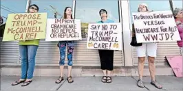  ?? TIMOTHY D. EASLEY/AP ?? Protesters who oppose Republican efforts to repeal the Affordable Care Act wait for Senate Majority Leader Mitch McConnell outside a GOP event Friday in Elizabetht­own, Ky.