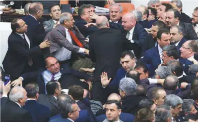  ??  ?? ... Lawmakers from ruling AK Party and the main opposition Republican People’s Party (CHP) scuffle during a debate on proposed constituti­onal changes to expand the powers of President Tayyip Erdogan at the Turkish Parliament in Ankara yesterday. During...