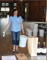  ?? The Sentinel-Record/Richard Rasmussen ?? LARGE ORDER: Co-owner Mary Bradley carries a 5-gallon container of Crystal Ridge Distillery’s hand sanitizer out to a customer on Friday.