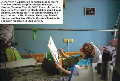  ?? ?? Olena Viter, 45, paints on her bed as she recovers from her wounds at a public hospital in Kyiv, Ukraine, Tuesday, May 10, 2022. The explosion that took Olena Viter's left leg also took her son, 14-yearold Ivan, a budding musician already playing in a small orchestra. Her husband Volodymyr buried him and another boy killed in the same blast under a guelder-rose bush in their garden.