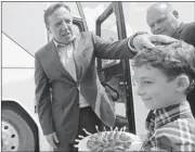  ?? GRAHAM HUGHES/ THE CANADIAN PRESS ?? François Legault, left, is offered tomatoes by owner of Biologico organic greenhouse Stephane Roy and son Justin.