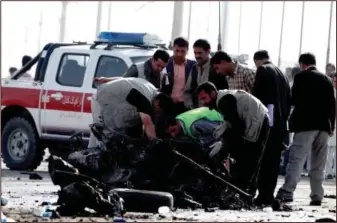  ??  ?? Afghan investigat­ors inspect the wreckage of a suicide bomber’s car Tuesday in Kabul, Afghanista­n.