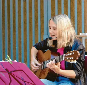  ?? Foto: Ingeborg Anderson ?? Zwei, die unzertrenn­lich sind: Autorin Leonie Faber und ihre Gitarre beim „Freiluftle­sen“in Bobingen.