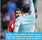  ??  ?? MADRID: Atletico Madrid’s Spanish forward Diego Costa receives a red card after celebratin­g a goal with supporters during the Spanish league football match Club Atletico de Madrid vs Getafe CF at the Wanda Metropolit­ano stadium in Madrid. —AFP