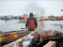  ?? STEPHEN YANG/GETTY ?? Campers set fireWednes­day to makeshift housing as part of a ceremony before leaving.