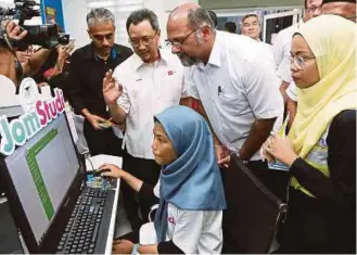  ??  ?? Gobind Singh Deo listening to a briefing on the use of the JomStudi applicatio­n by Kamal Khalid at the launch of the JomStudi Programme at Kampung Kering Internet Centre, Labu, Negeri Sembilan. PICS BY IQMAL HAQIM ROSMAN