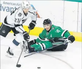 ?? LM Otero Associated Press ?? DUSTIN BROWN of the Kings takes control of the puck in front of Dallas Stars left wing Patrick Sharp during the first period.