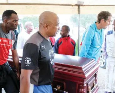  ?? Photos: Sue Maclennan ?? Runners carry the coffin of Eric Mapara into the family home on Saturday 22 April. The had formed a guard of honour earlier to lead the hearse there from Matebese Funeral Parlour in M Street.
