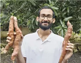  ?? Sijo Zachariah via AP ?? Sijo Zachariah shows off tapioca roots harvested from the farm that he and his father started during coronaviru­s lockdown in Alappuzha in the Indian state of Kerala.