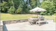  ??  ?? Embraced by stone walls, the bluestone patio steps out to a private, level lawn.