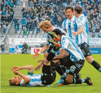  ??  ?? Komm, lass dich umarmen: Kai Bülow (liegend) wird von seinen Mannschaft­skollegen für den späten Siegtreffe­r gegen Karlsruhe bejubelt.