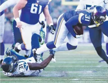  ??  ?? Seahawks safety Kam Chancellor tries to tackle the Vikings’ Jerick McKinnon during an NFC wild-card playoff game last Sunday in frigid Minneapoli­s. Jamie Squire, Getty Images