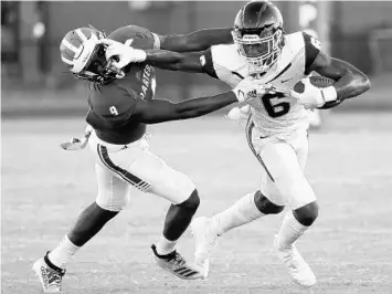  ?? STEPHEN M. DOWELL/ORLANDO SENTINEL ?? Dr. Phillips receiver Joanes Fortilien stiff-arms Apopka defender Andre Phillips during Friday night’s game.