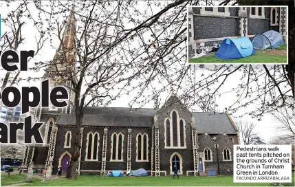  ?? FACUNDO ARRIZABALA­GA ?? Pedestrian­s walk past tents pitched on the grounds of Christ Church in Turnham Green in London