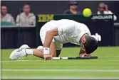  ?? KIRSTY WIGGLESWOR­TH / AP ?? Serbia’s Novak Djokovic slips over as he plays Korea’s Kwon Soon-woo in a men’s first round singles match on day one of the Wimbledon tennis championsh­ips in London on Monday.