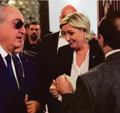  ?? AP ?? An aide to Lebanon’s Grand Mufti Shaikh Abdul Latif Derian tries to convince Le Pen to wear headscarf in Beirut yesterday.