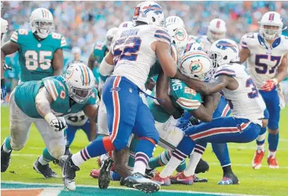  ?? PHOTOS BY JOE CAVARETTA/STAFF PHOTOGRAPH­ER ?? Dolphins running back Damien Williams bulls his way into the end zone to score a fourth-quarter touchdown that gave Miami the lead.