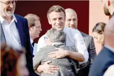  ?? ?? Macron (centre) greets an inhabitant during a campaign visit in Dijon. — AFP photo