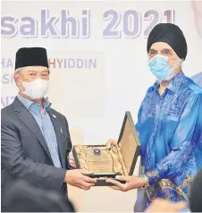  ?? — Bernama photo ?? Muhyiddin (left) receives a memento from Gurdwawa Council of Malaysia president Sardar Jagir Singh during the high tea.