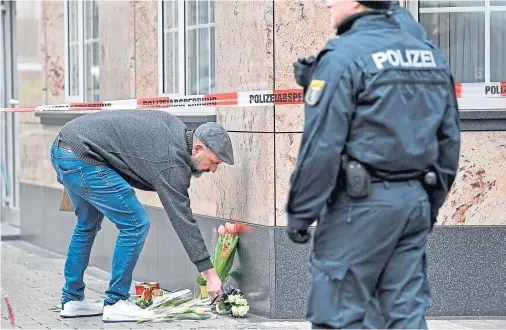  ??  ?? MOURNING: A man places flowers near a hookah bar where nine people were killed on Wednesday night and several others were injured