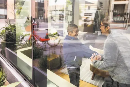  ?? Santiago Mejia / The Chronicle ?? Olivia Fraga and her son, Martin, interact in their apartment lobby in San Francisco during the coronaviru­s pandemic.