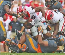  ?? STAFF PHOTO BY ERIN O. SMITH ?? Tennessee defensive tackle Shy Tuttle, bottom, works to bring down Georgia tailback Brian Herrien during their SEC East matchup in September. Tuttle’s first two college seasons ended because of injuries, but he has started the past two weekends and is...