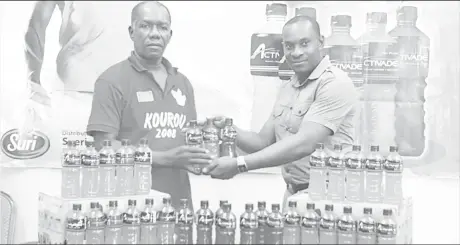  ??  ?? Sueria Manufactur­ing Inc. Brand Manager Selwyn Bobb (right) hands over some of the Activade Energy Drinks to GCF Assistant Racing Secretary, Joseph Britton.