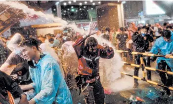  ?? JACK TAYLOR/GETTY-AFP ?? Thailand protests: Thousands of student-led protesters, in defiance of a state of emergency, converged for a second straight day Friday in Bangkok. Using water cannons, riot police also cracked down on protesters by charging into the crowd. Meanwhile, Prime Minister Prayuth Chan-ocha rejected demands from protesters that he resign.