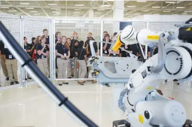  ?? STAFF FILE PHOTO ?? Jeff Hood, not pictured, operates one of the stations in the Volkswagen Academy while students from the Governor’s School for Emerging Technology at Tennessee Tech watch at the Volkswagen Academy in Chattanoog­a. The first Smart Factory Institute will open in the academy this fall.