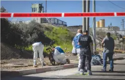  ?? (Chaim Goldberg/Flash90) ?? POLICE AND SECURITY personnel are at the scene of a stabbing attack near Jerusalem, earlier this month.