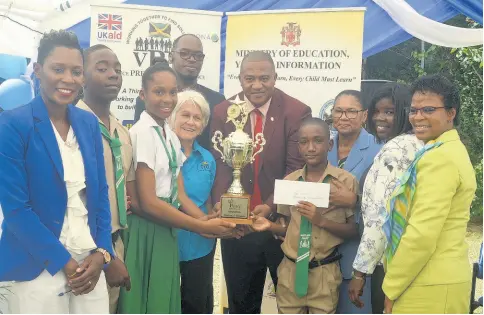  ?? PHOTO BY CHRISTOPHE­R THOMAS ?? Richard Troupe (centre), acting director of the Ministry of Education’s Safety and Security Unit, participat­es in a group shot for the presentati­on of the first-place trophy to Maryland All-Age following the school’s participat­ion in the 2019-20 Trees for Peace competitio­n. Posing with Troupe are (from left) Andria Dehaney-Grant, principal; Tyrone Miller and Jody-Ann Hylton, grade six students of Maryland All-Age School; Everett Riley, senior education officer; Elizabeth Ward, chairman of the Violence Prevention Alliance; Kenoy Smith, sixth-grader; Patricia Haughton, senior education officer; Kerel Samuels, senior teacher; and Yvonne Ward-Hardie, education officer.