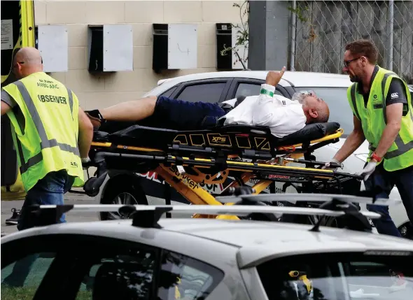  ?? MARK BAKER / THE ASSOCIATED PRESS ?? Ambulance staff take a man from outside a mosque in Christchur­ch, New Zealand, on Friday, after a shooting rampage that left at least 49 people dead and dozens injured.