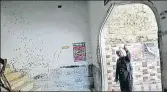  ?? REUTERS ?? A policeman gestures beside a wall with shrapnel marks, damaged in a suicide blast in a Shia mosque in 2015.