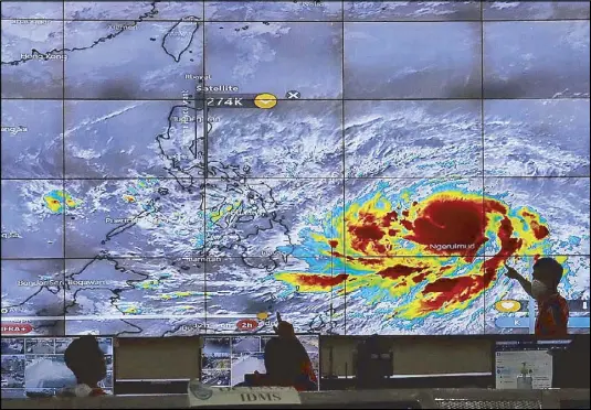  ??  ?? The Quezon City Disaster Risk Reduction and Management Office monitors the path of severe tropical storm ‘Surigae’ (internatio­nal name) as it enters the Philippine area of responsibi­lity yesterday, becoming storm ‘Bising.’ Related story on Page 7.