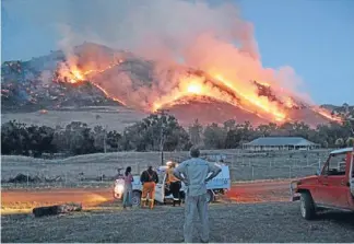  ?? Photo: Tony Engel ?? Baptism of bushfire: Flames rise above Jugiong, north of Canberra, on Tuesday. Farmers with surviving stock were seeking donations of feed as their paddocks were razed.