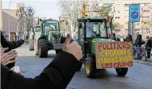  ?? /Reuters ?? Backing: Residents show support in Madrid on February 21 as Spanish farmers drive their tractors during a protest over price pressures, taxes and green regulation.