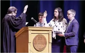  ?? STAFF PHOTOS BY C.B. SCHMELTER ?? Jenny Hill, second from right, is sworn in as a councilwom­an by Judge Clarence Shattuck, left, during the inaugurati­on ceremony at the Tivoli Theatre on Monday.