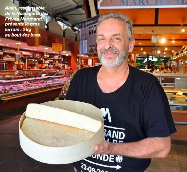  ??  ?? Alain, responsabl­e de la fromagerie des Frères Marchand, présente le gros lorrain : 5 kg au bout des bras.