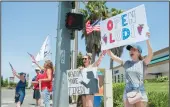  ??  ?? Rebekah Panos of Acampo and Vanessa Valle of Lodi support the Open Lodi protest in Lodi on Saturday.