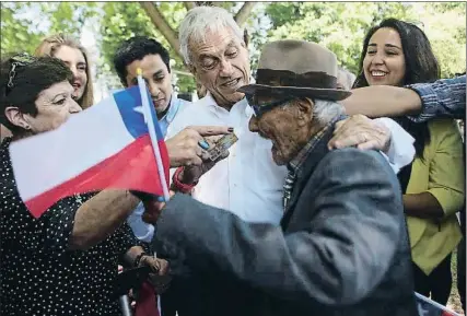  ?? CLAUDIO REYES / AFP ?? Piñera bromeando con un pensionist­a, durante un picnic electoral, el viernes en Santiago