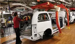  ?? (Rebecca Cook/Reuters) ?? FIAT CHRYSLER assembly workers work on minivans at the Windsor Assembly Plant in Windsor, Ontario.