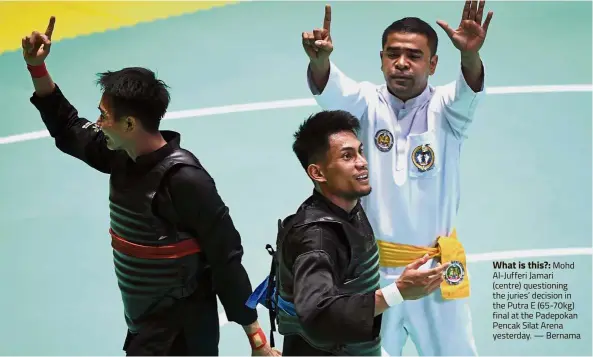  ??  ?? What is this?: Mohd Al-Jufferi Jamari (centre) questionin­g the juries’ decision in the Putra E (65-70kg) final at the Padepokan Pencak Silat Arena yesterday. — Bernama