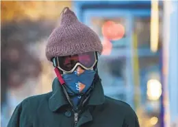  ?? ROBERT F. BUKATY AP ?? Thomas Nosal wears a hat over his helmet Tuesday following his bicycle commute to his job in Portland, Maine, which is being hit with bitterly cold weather.