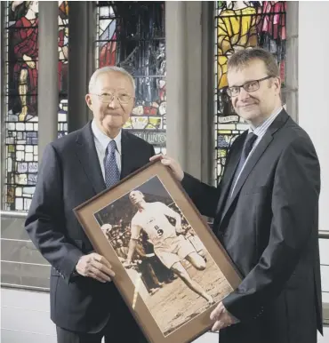  ??  ?? 0 Dr HK Cheng and John Macmillan with a photograph of Eric Liddell in action for the British Empire versus the US