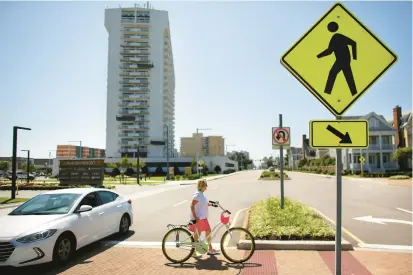  ?? STEPHEN M. KATZ/THE VIRGINIAN-PILOT ?? Instead of stopping, a car swerves around Michele Minetola, vacationin­g from Allentown, Pennsylvan­ia, on Wednesday at the pedestrian crossing along Atlantic Avenue in front of Virginia Beach’s historic Cavalier Hotel, where there is no traffic signal.