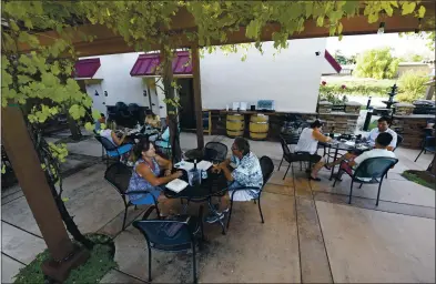  ?? PHOTOS BY JOSE CARLOS FAJARDO — STAFF PHOTOGRAPH­ER ?? Roni Wilcox, of Livermore, and her husband, Bruce Wilcox, enjoy a glass of wine on the outdoor patio at Dante Robere Vineyards in Livermore as wineries reopen to customers for socially distanced sipping after months of closures due to the coronaviru­s pandemic.