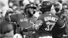  ?? COLE BURSTON/GETTY IMAGES ?? Blue Jays slugger Vladimir Guerrero Jr. celebrates with Teoscar Hernandez after hitting his league-leading 45th home run of the season.