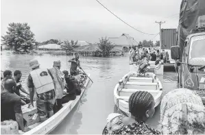  ?? — Gambar AFP ?? BANJIR: Penduduk dipindahka­n dengan menaiki bot dari kawasan terjejas teruk akibat banjir selepas hujan lebat di kampung Mohoro, Daerah Rufiji baru-baru ini.