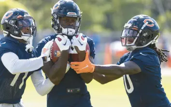  ?? ?? Wide receiver Byron Pringle, center, practices with Darnell Mooney, left, and Nsimba Webster during Monday’s practice at Halas Hall.
