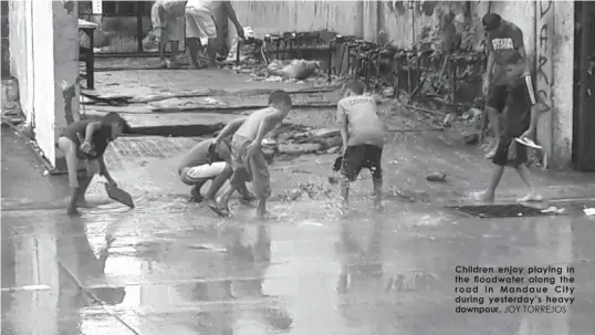  ?? JOY TORREJOS ?? Children enjoy playing in the floodwater along the road in Mandaue City during yesterday’s heavy downpour.